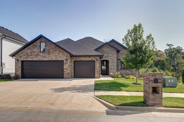 view of front facade featuring brick siding, a garage, a front lawn, driveway, and roof with shingles