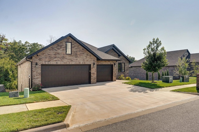 view of front facade featuring brick siding, concrete driveway, an attached garage, a front yard, and a shingled roof