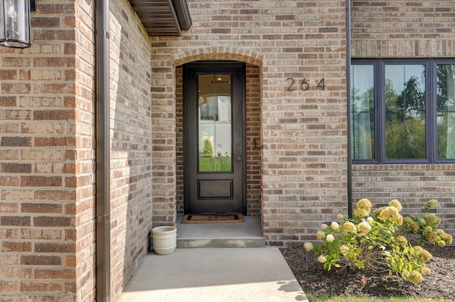 view of exterior entry featuring brick siding