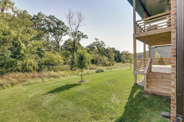view of green lawn featuring a deck