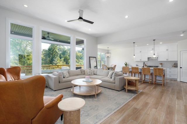 living area featuring recessed lighting, light wood-type flooring, and ceiling fan