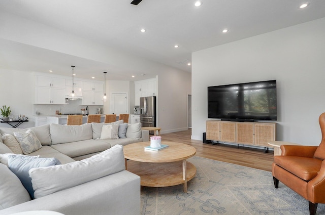 living room with recessed lighting, light wood finished floors, and baseboards