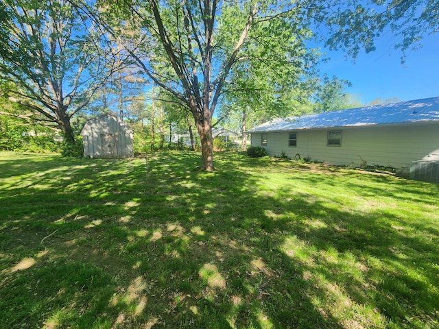 view of grassy yard featuring a shed and an outdoor structure