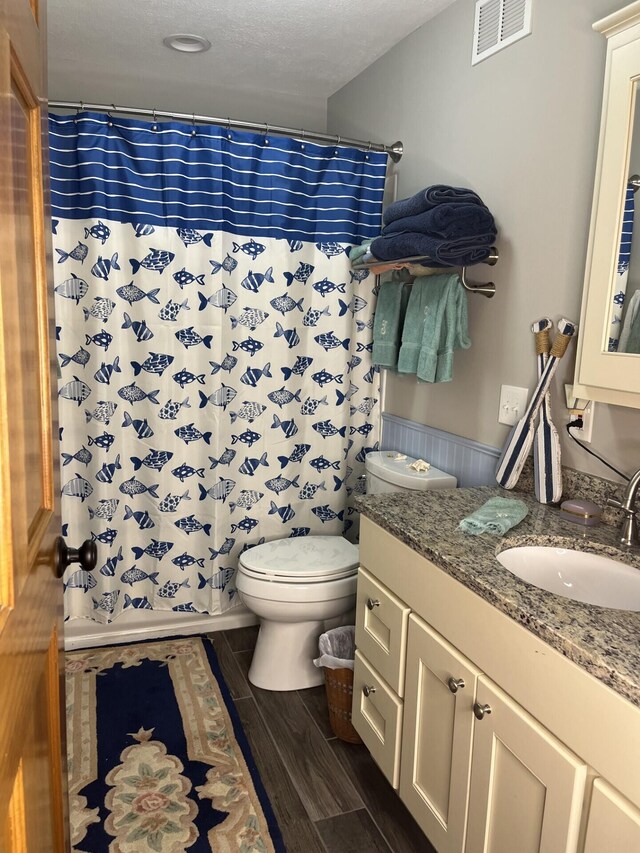 full bathroom featuring toilet, vanity, wood finished floors, and shower / bath combo