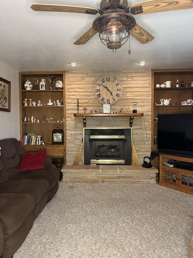 carpeted living room with a fireplace, ceiling fan, and wooden walls