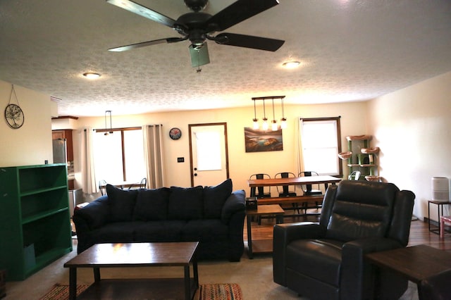 living room featuring ceiling fan and a textured ceiling