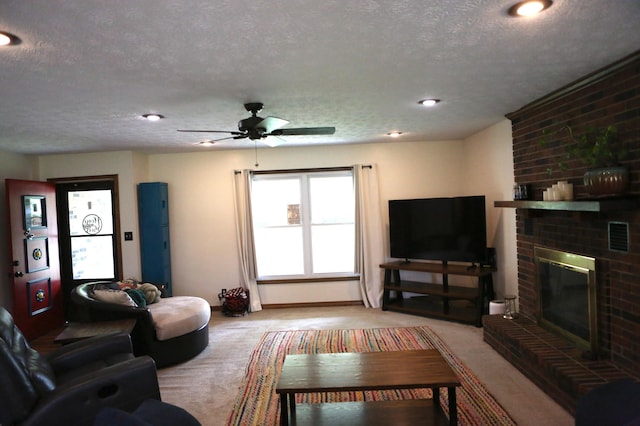 carpeted living room with a textured ceiling, a fireplace, and a ceiling fan
