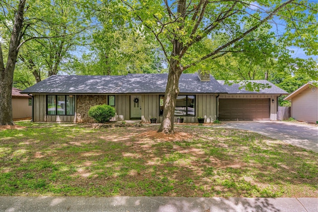 view of front of home featuring driveway, board and batten siding, an attached garage, roof with shingles, and fence