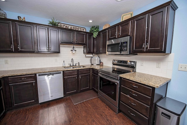 824 E Crystal Ave, Nixa, MO 65714 - kitchen with stainless steel appliances, a sink, dark wood-style floors, dark brown cabinetry, and backsplash