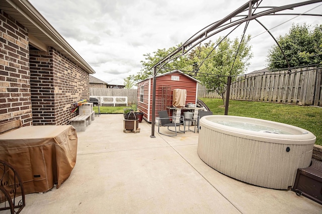 824 E Crystal Ave, Nixa, MO 65714 - view of patio featuring a hot tub, a fenced backyard, a storage unit, and an outdoor structure