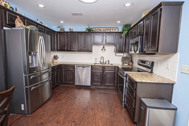 824 E Crystal Ave, Nixa, MO 65714 - kitchen with appliances with stainless steel finishes, a sink, dark brown cabinetry, dark wood finished floors, and light stone countertops