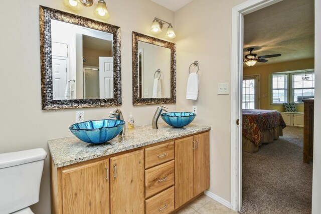 147 Liberty Ln, Kimberling City, MO 65686 - ensuite bathroom featuring a ceiling fan, toilet, double vanity, and tile patterned floors