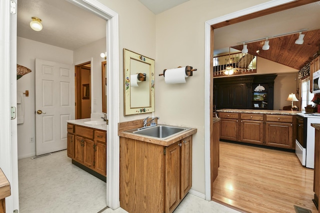 147 Liberty Ln, Kimberling City, MO 65686 - bathroom with two vanities, vaulted ceiling, baseboards, and wood finished floors