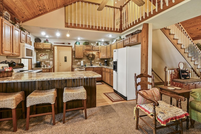 147 Liberty Ln, Kimberling City, MO 65686 - kitchen with white appliances, a peninsula, high vaulted ceiling, a sink, and light carpet
