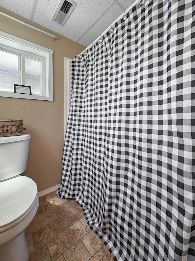 147 Liberty Ln, Kimberling City, MO 65686 - bathroom featuring toilet, baseboards, curtained shower, and stone finish flooring