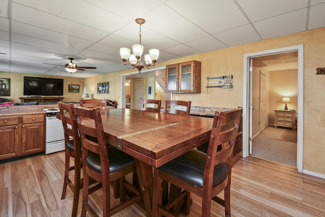 147 Liberty Ln, Kimberling City, MO 65686 - dining space featuring a drop ceiling, light wood finished floors, a ceiling fan, and a chandelier