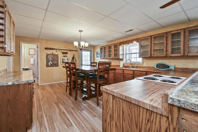 147 Liberty Ln, Kimberling City, MO 65686 - kitchen with a drop ceiling, a sink, stovetop, glass insert cabinets, and light wood finished floors