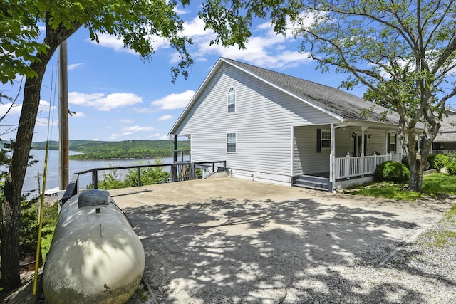 147 Liberty Ln, Kimberling City, MO 65686 - view of property exterior with a porch, a water view, and a shingled roof