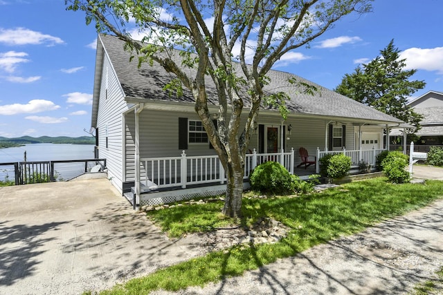 147 Liberty Ln, Kimberling City, MO 65686 - view of front of home with covered porch, a water view, roof with shingles, and a garage
