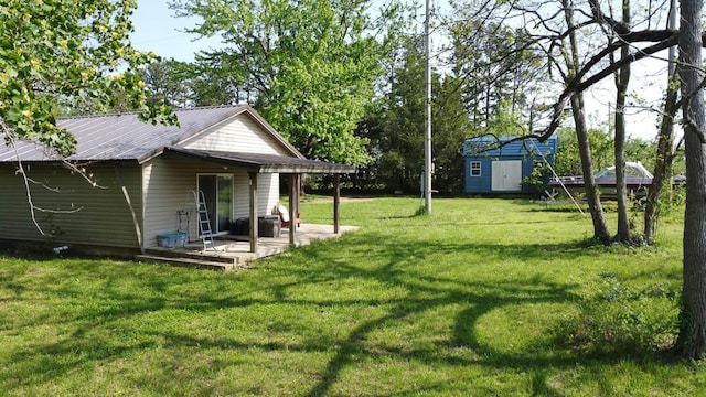 468 Martingale Dr, Theodosia, MO 65761 - view of grassy yard featuring a storage shed, an outbuilding, and a patio