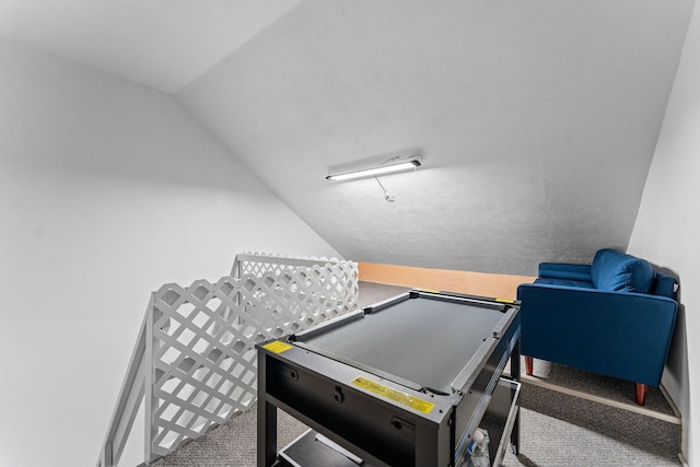 game room with vaulted ceiling and carpet