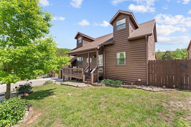 view of front of home with roof with shingles, a wooden deck, and log veneer siding