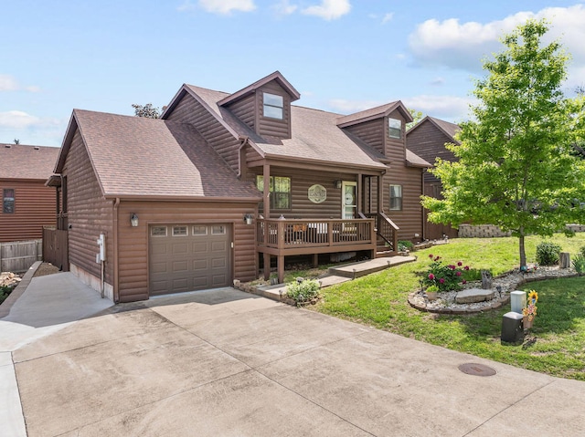 view of front facade with driveway, an attached garage, a front yard, roof with shingles, and faux log siding