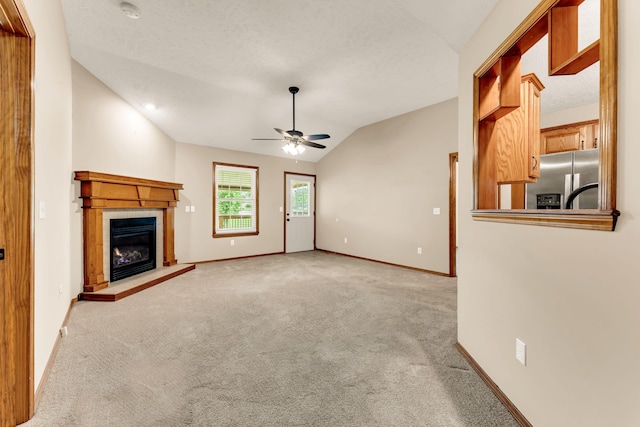 3742 W Village Ter, Springfield, MO 65810 - unfurnished living room with ceiling fan, carpet flooring, lofted ceiling, baseboards, and a tiled fireplace