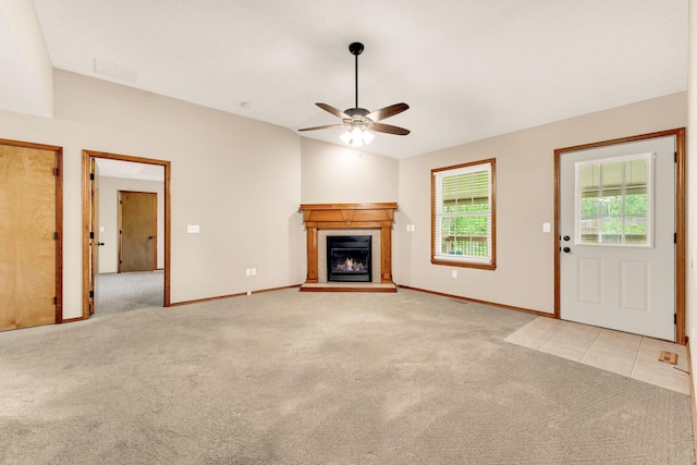 3742 W Village Ter, Springfield, MO 65810 - unfurnished living room with light colored carpet, vaulted ceiling, a ceiling fan, a tiled fireplace, and baseboards