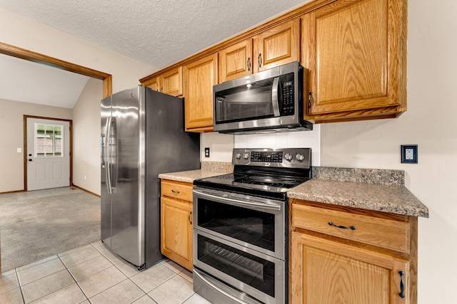 3742 W Village Ter, Springfield, MO 65810 - kitchen featuring stainless steel appliances, light carpet, light tile patterned floors, and lofted ceiling
