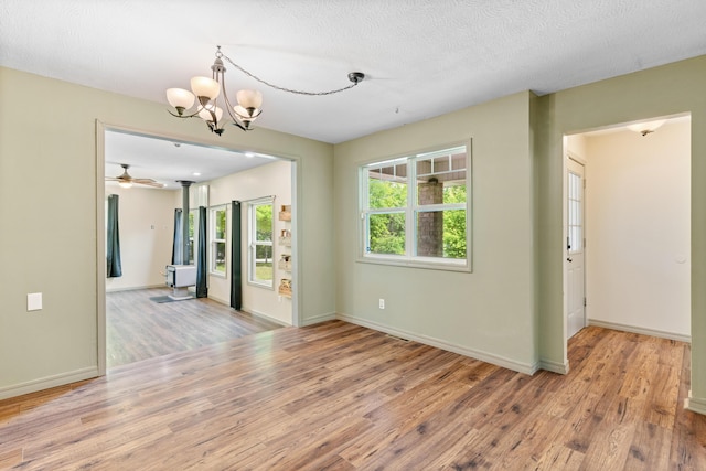 245 Country Hills Rd, Branson, MO 65616 - unfurnished room with wood finished floors, a chandelier, baseboards, and a ceiling fan