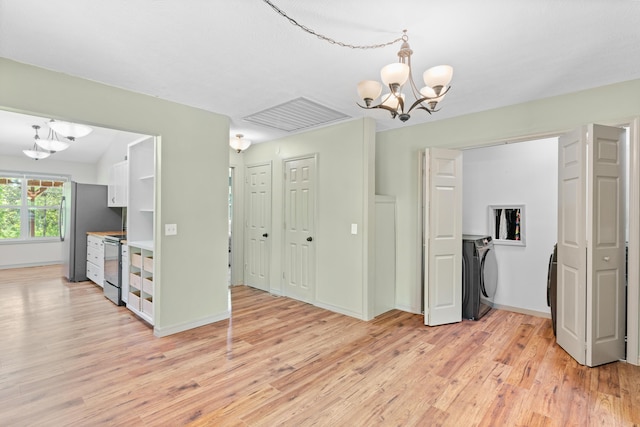 245 Country Hills Rd, Branson, MO 65616 - unfurnished dining area featuring washer / clothes dryer, a chandelier, and light wood-type flooring