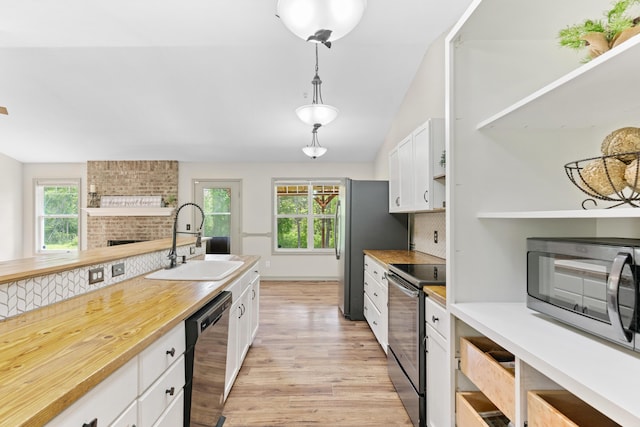 245 Country Hills Rd, Branson, MO 65616 - kitchen featuring a sink, stainless steel appliances, light wood finished floors, white cabinetry, and decorative light fixtures