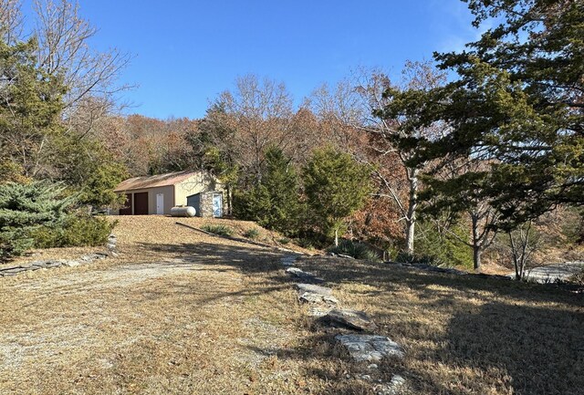 view of side of property with a wooded view and an outdoor structure