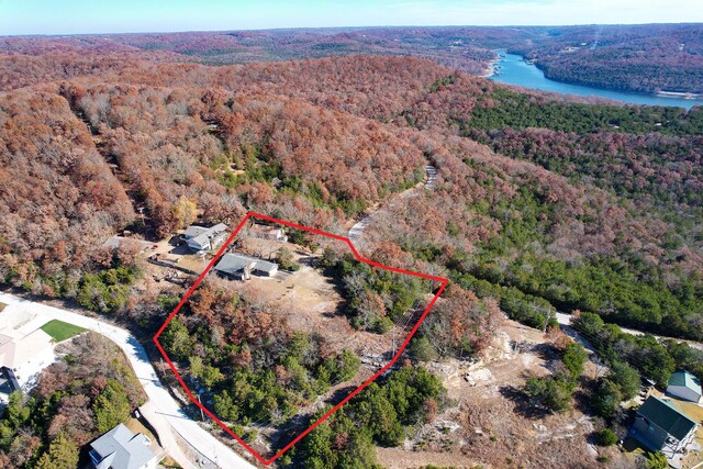 aerial overview of property's location featuring a forest, a nearby body of water, and property boundaries highlighted