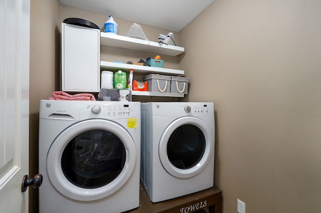 clothes washing area with washing machine and dryer