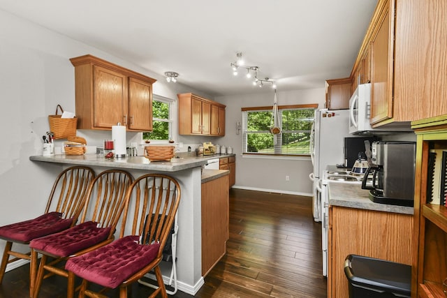 138 Canyon Forest Cir, Kimberling City, MO 65686 - kitchen featuring white appliances, a peninsula, dark wood-type flooring, brown cabinets, and baseboards