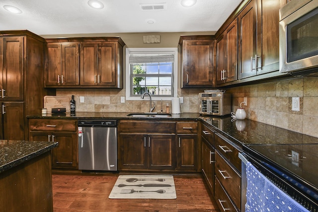 2107 S Gristmill Ct, Ozark, MO 65721 - kitchen with appliances with stainless steel finishes, a sink, dark stone counters, dark wood-style flooring, and recessed lighting
