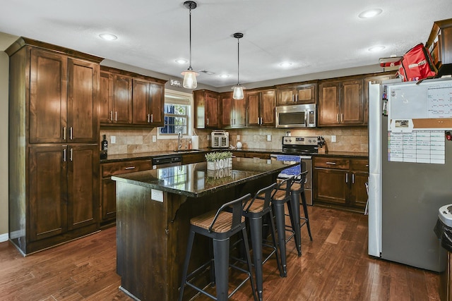 2107 S Gristmill Ct, Ozark, MO 65721 - kitchen with appliances with stainless steel finishes, a sink, dark wood-style floors, tasteful backsplash, and recessed lighting
