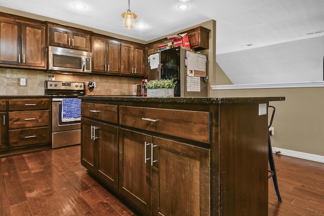 2107 S Gristmill Ct, Ozark, MO 65721 - kitchen featuring appliances with stainless steel finishes, dark wood-style floors, baseboards, decorative backsplash, and decorative light fixtures