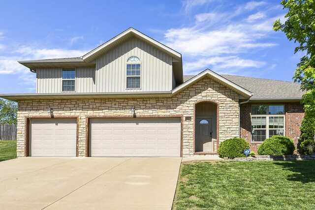 2107 S Gristmill Ct, Ozark, MO 65721 - view of front of house with concrete driveway, a front yard, a garage, board and batten siding, and stone siding