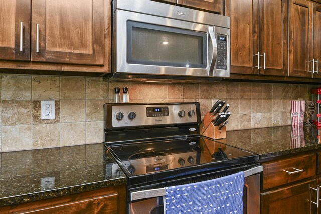 2107 S Gristmill Ct, Ozark, MO 65721 - kitchen featuring stainless steel appliances, backsplash, dark stone counters, and dark brown cabinetry