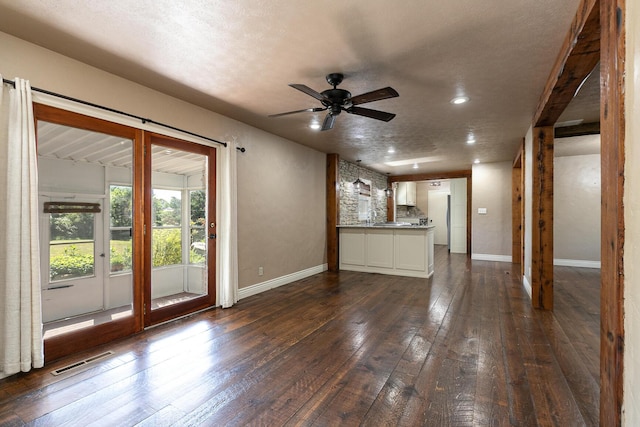 unfurnished living room with dark wood-style floors, baseboards, ceiling fan, a textured ceiling, and recessed lighting