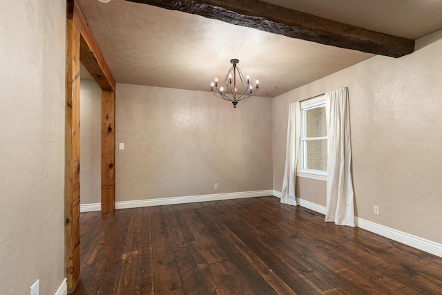 empty room featuring a chandelier, dark wood-style flooring, beam ceiling, and baseboards