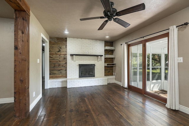 unfurnished living room with hardwood / wood-style flooring, ceiling fan, baseboards, and a fireplace