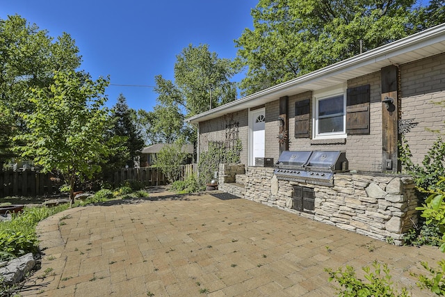 view of patio / terrace with area for grilling and fence