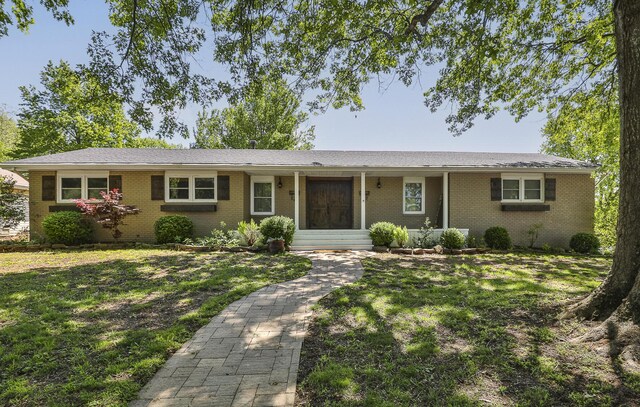 ranch-style home featuring brick siding and a front lawn