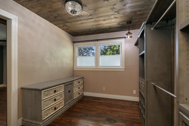 unfurnished dining area featuring dark wood-style flooring, wooden ceiling, and baseboards