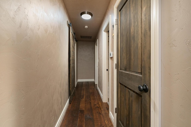 hallway featuring dark wood-style flooring and baseboards