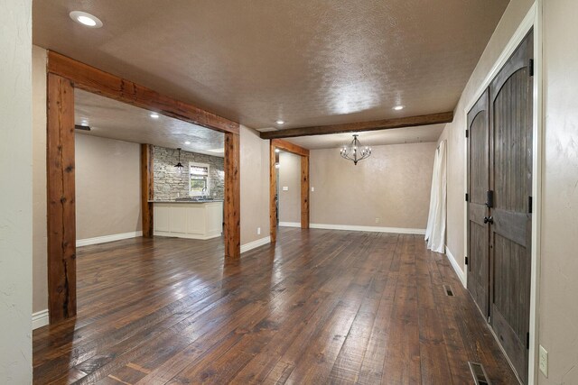 below grade area with dark wood finished floors, a textured ceiling, a chandelier, recessed lighting, and baseboards